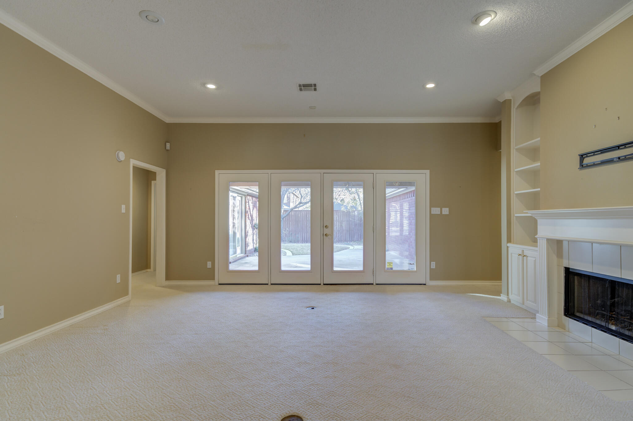 5917 85th Street Lubbock, TX 79424 - Photo 9 of 51 a view of an empty room with a fireplace and a window