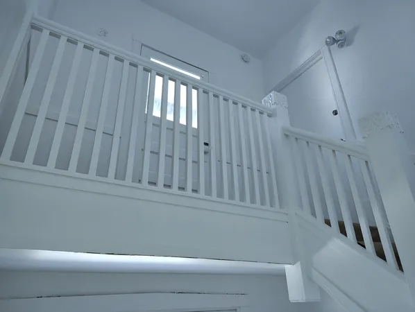 a view of staircase with white walls and railing