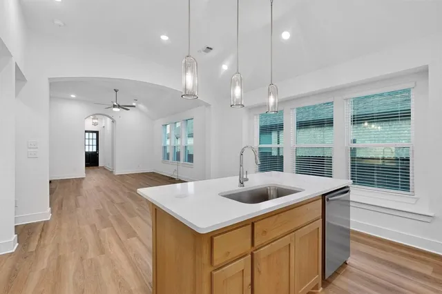 a kitchen with a sink a counter space and living room view