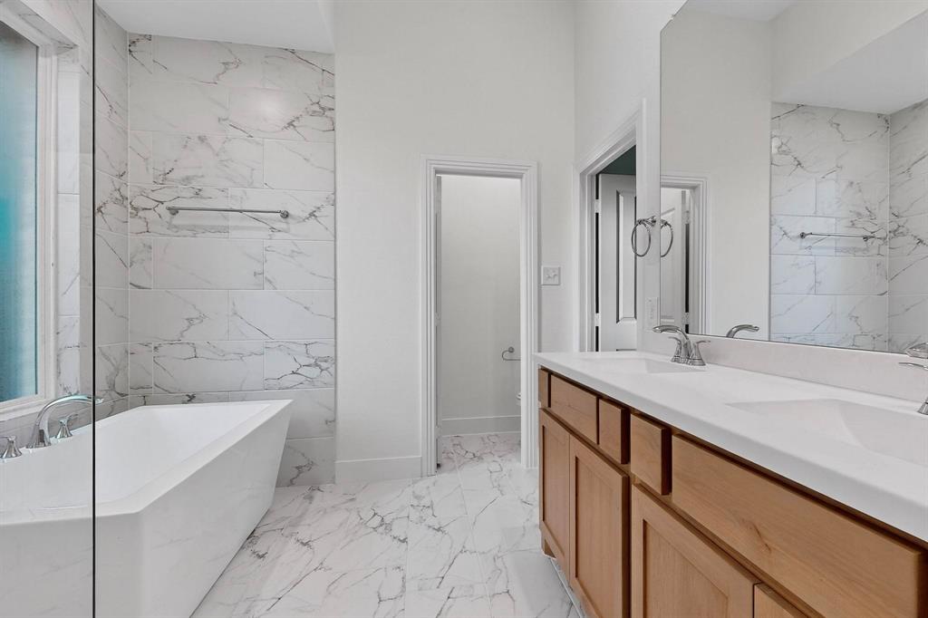 1232 Newport Street Sherman, TX 75090 - Photo 21 of 40 a bathroom with a granite countertop sink a mirror and a bathtub