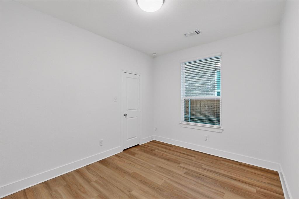1232 Newport Street Sherman, TX 75090 - Photo 23 of 40 a view of an empty room with wooden floor and a window