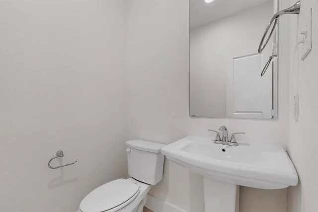 a white toilet sitting next to a bathroom sink