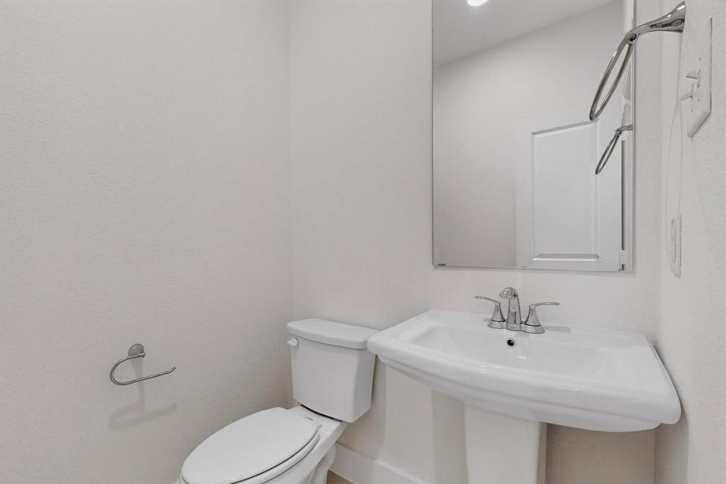 1232 Newport Street Sherman, TX 75090 - Photo 31 of 40 a white toilet sitting next to a bathroom sink