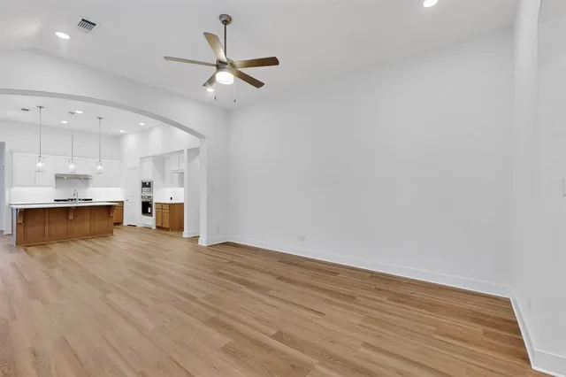 a view of kitchen with stove and white cabinets