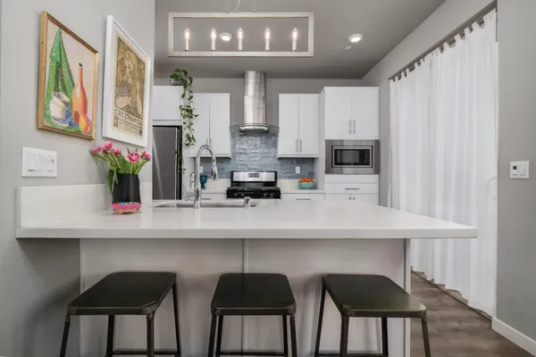 a kitchen with stainless steel appliances granite countertop a refrigerator and a stove top oven