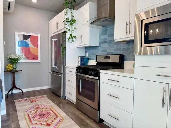 a kitchen with stainless steel appliances granite countertop a refrigerator stove and cabinets