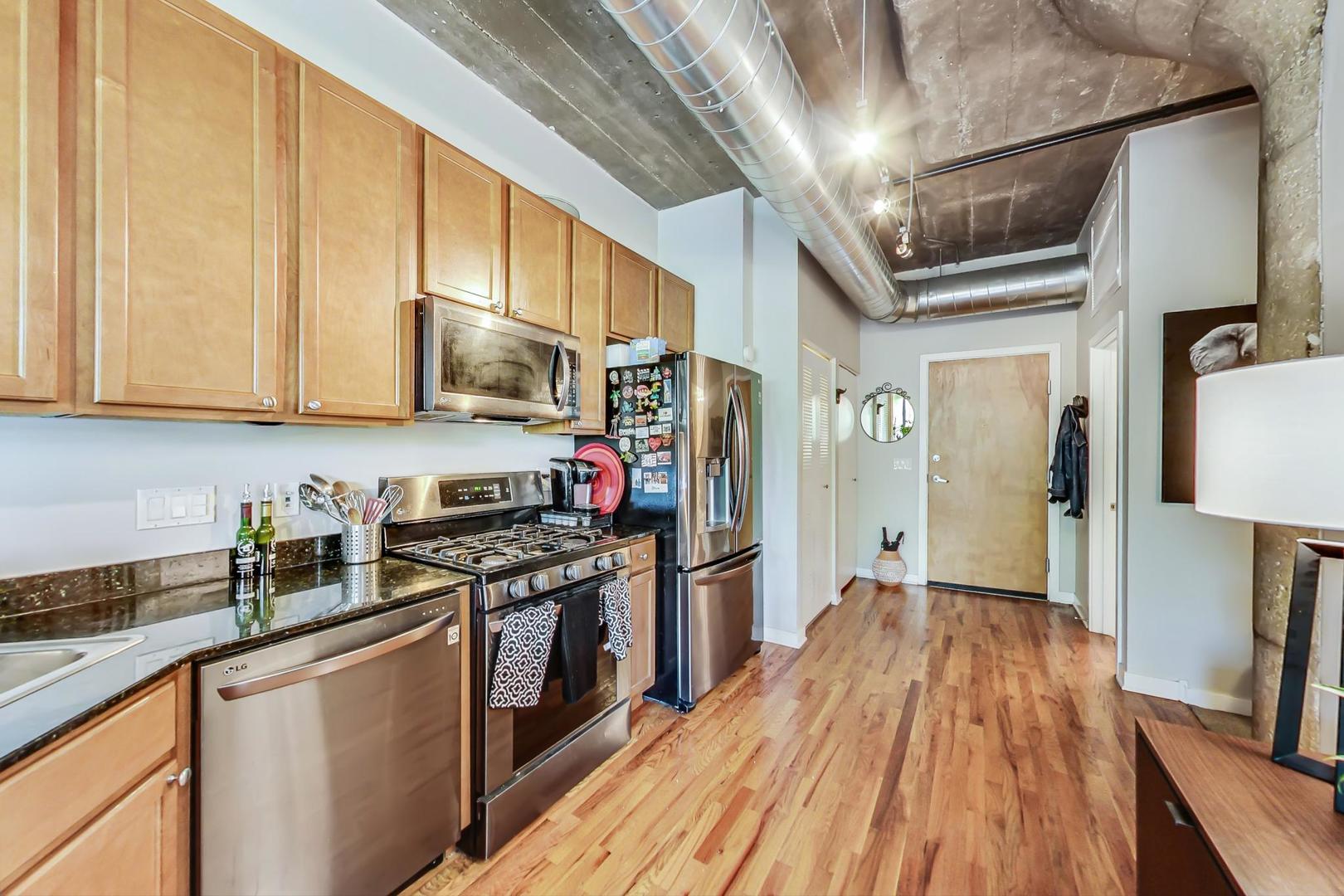 1111 West 15th Street, Unit 221 Chicago, IL 60608 - Photo 11 of 21 a kitchen with stainless steel appliances granite countertop a refrigerator a stove top oven a sink and dishwasher