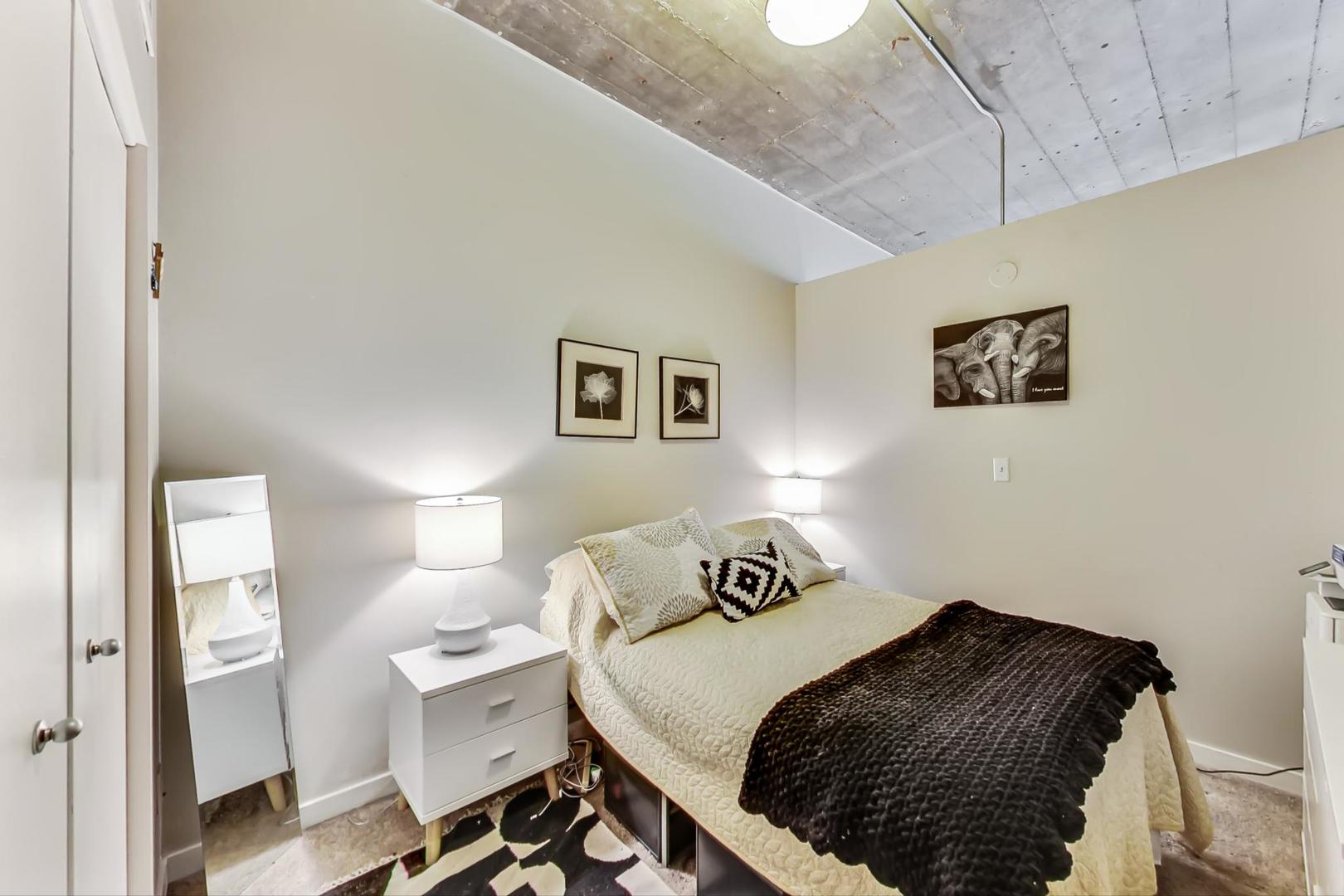 1111 West 15th Street, Unit 221 Chicago, IL 60608 - Photo 12 of 21 a bedroom with a bed and a painting on the wall