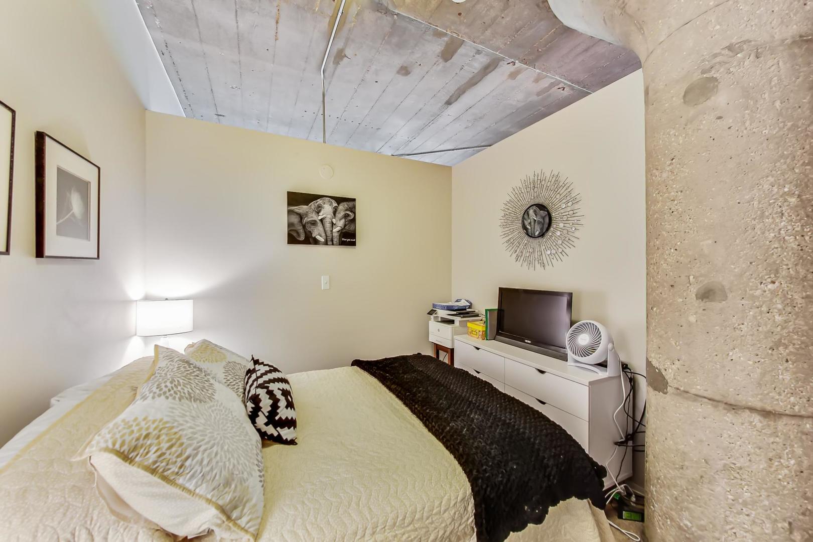 1111 West 15th Street, Unit 221 Chicago, IL 60608 - Photo 14 of 21 a bedroom with a bed and wooden floor