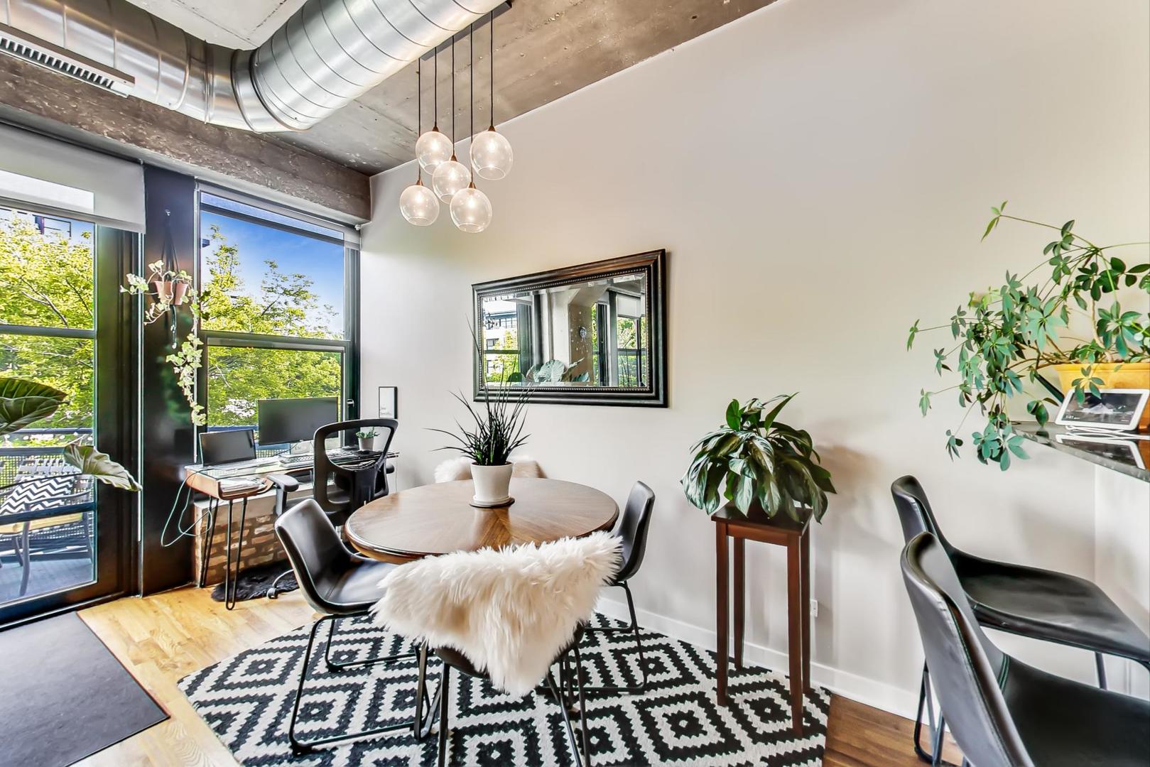 1111 West 15th Street, Unit 221 Chicago, IL 60608 - Photo 6 of 21 a dining room with furniture a large window and potted plants