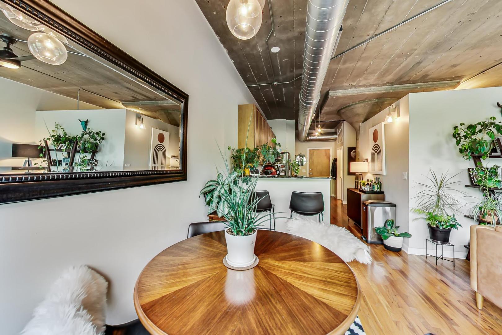 1111 West 15th Street, Unit 221 Chicago, IL 60608 - Photo 8 of 21 a view of a dining room with furniture wooden floor and a chandelier