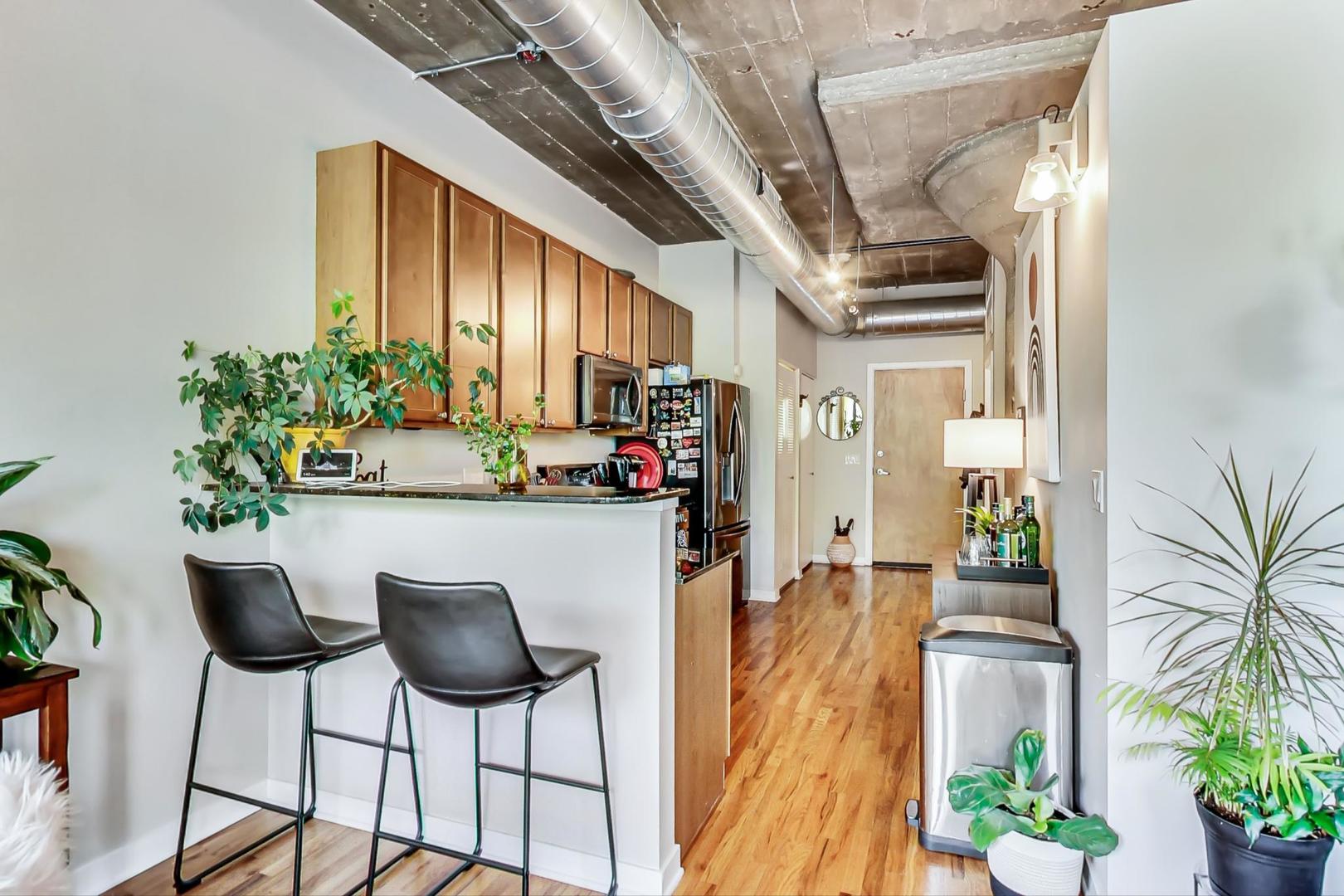 1111 West 15th Street, Unit 221 Chicago, IL 60608 - Photo 9 of 21 a dining room with stainless steel appliances a swimming pool and chairs