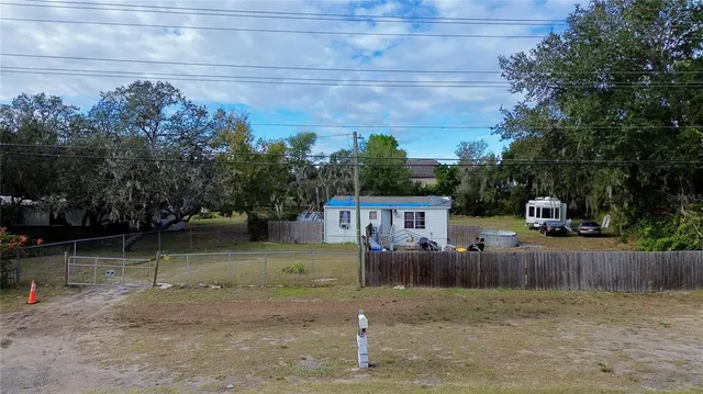 a backyard of apartments with large trees and wooden fence