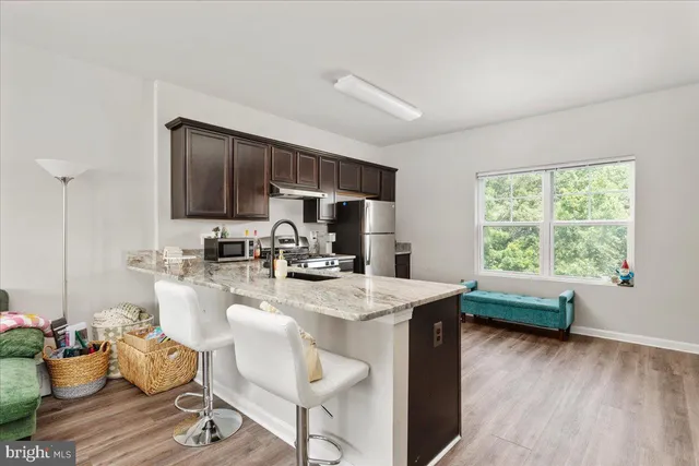 a living room with furniture a wooden floor and a large window
