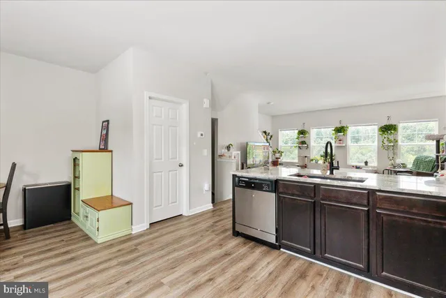 a kitchen with stainless steel appliances granite countertop a sink and a refrigerator