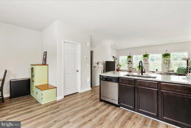 a kitchen with stainless steel appliances granite countertop a sink and a refrigerator