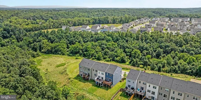 an aerial view of a house a yard and mountain