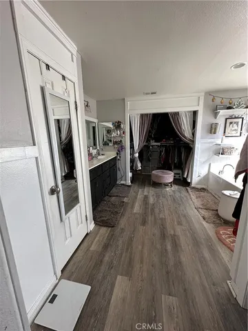 a view of a livingroom with wooden floor and electronic appliances