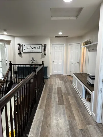 a view of a hallway with wooden floor and staircase