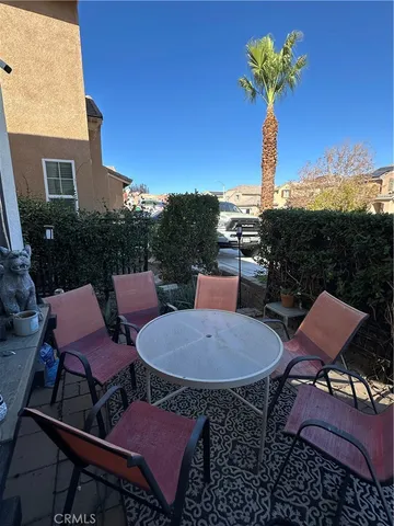 a front view of a house with garden and chairs