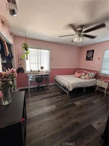 a spacious bedroom with a bed a table and a chandelier