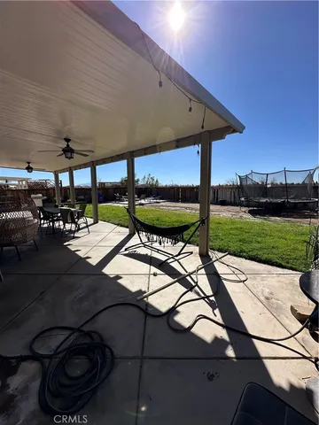 a view of a patio with table and chairs potted plants and large tree