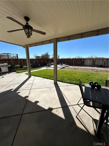 a view of a patio with a table and chairs under an umbrella