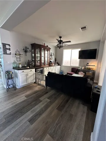 a living room with stainless steel appliances kitchen island granite countertop furniture a fireplace and a flat screen tv