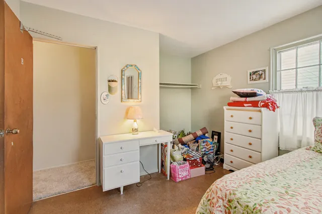 a bedroom with a bed and a dresser in it