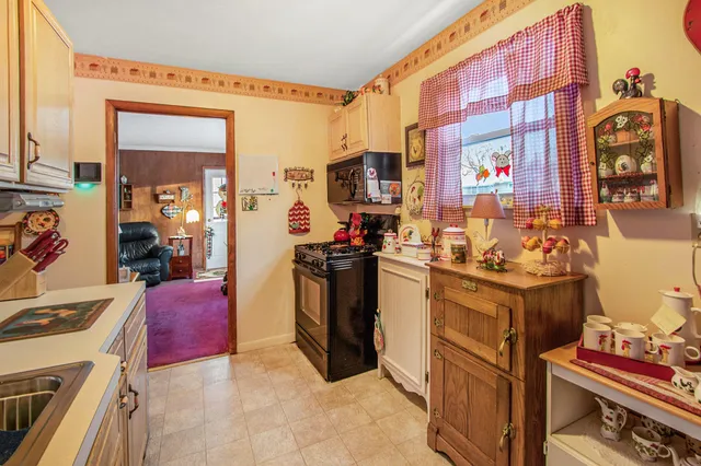a view of kitchen with stainless steel appliances kitchen island granite countertop a stove and a sink