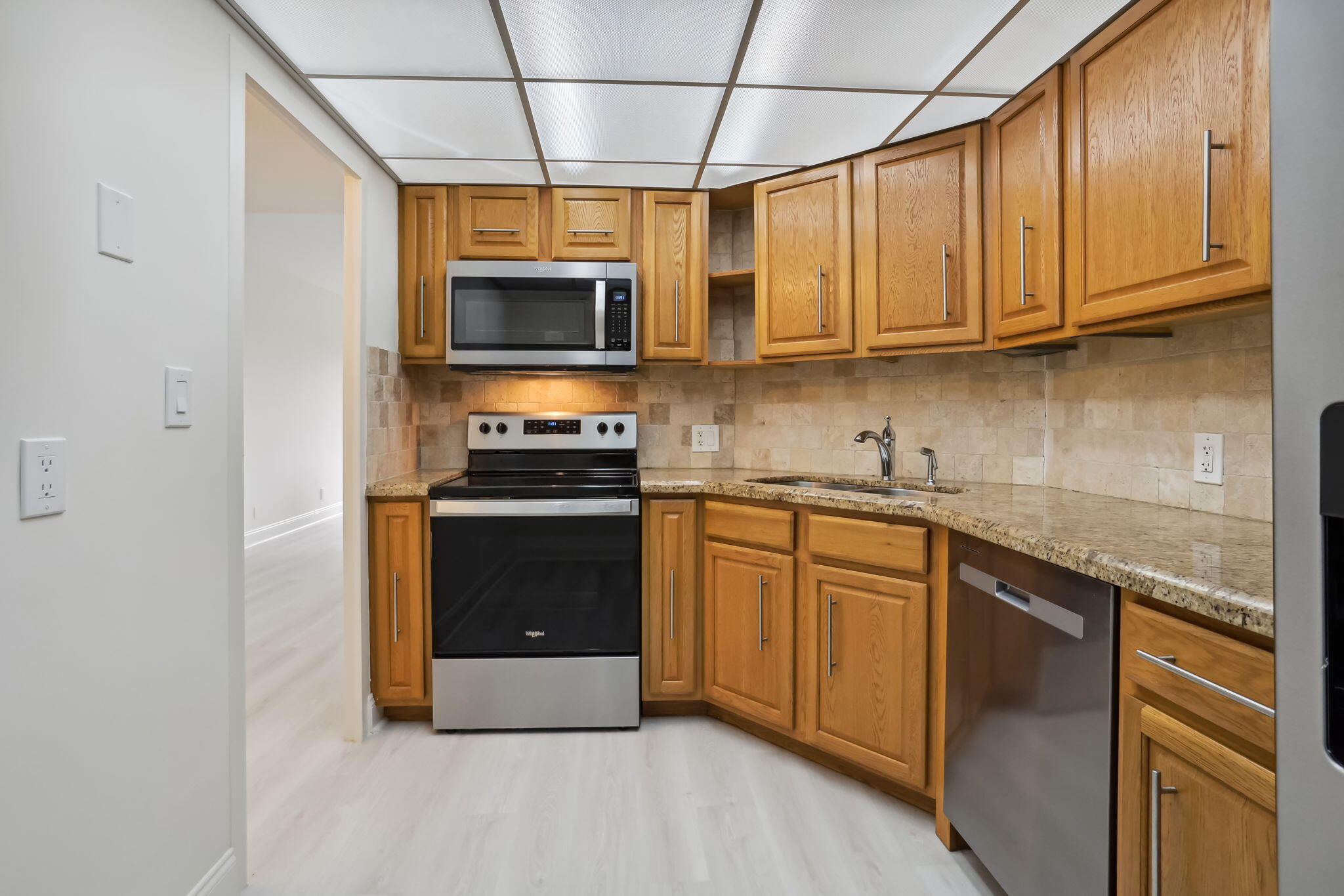 701 East Camino Real, Unit 6C Boca Raton, FL 33432 - Photo 21 of 53 a kitchen with stainless steel appliances granite countertop a stove a sink and a microwave