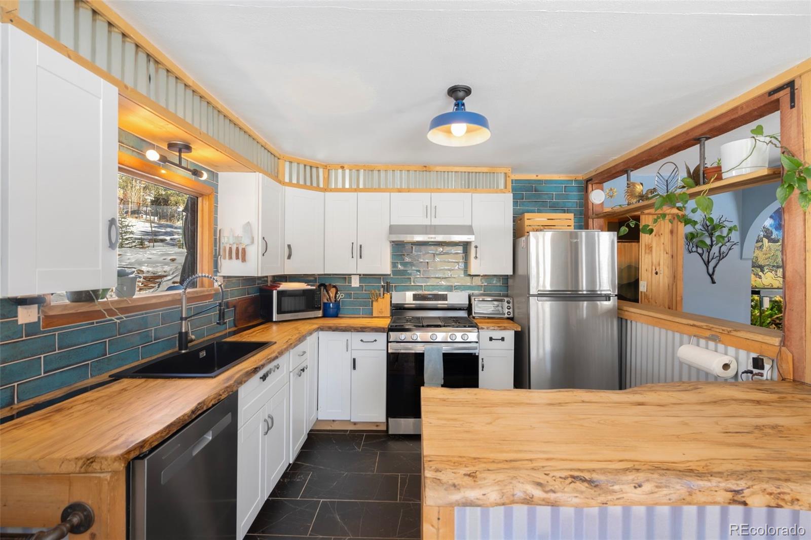 810 Larkspur Road Estes Park, CO 80517 - Photo 16 of 44 a kitchen with stainless steel appliances a refrigerator sink and wooden cabinets