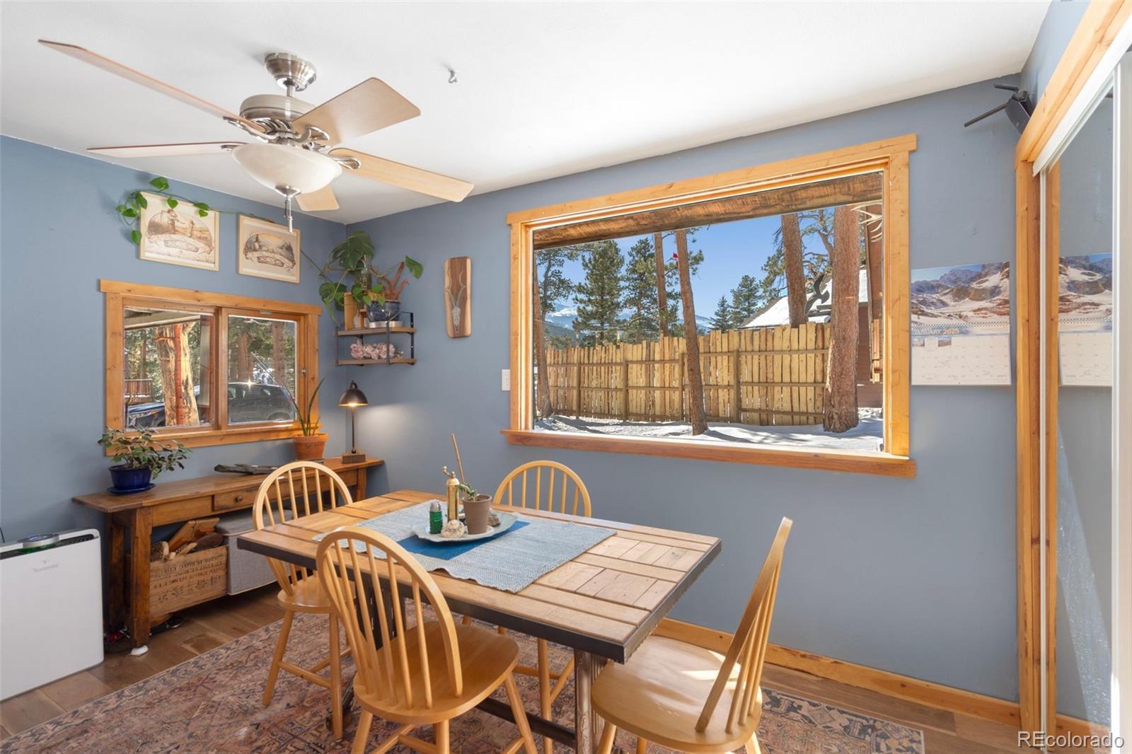 810 Larkspur Road Estes Park, CO 80517 - Photo 17 of 44 a view of a dining room with furniture a chandelier and large window