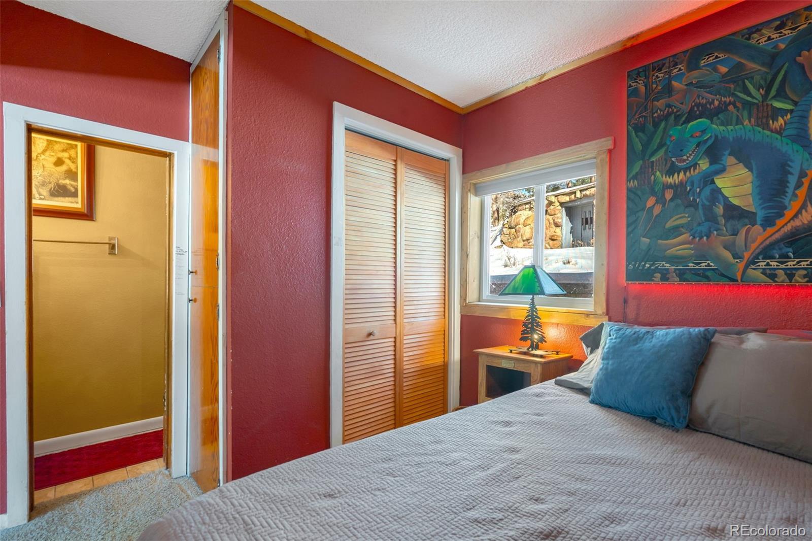 810 Larkspur Road Estes Park, CO 80517 - Photo 23 of 44 a bedroom with a bed and a dresser next to a window