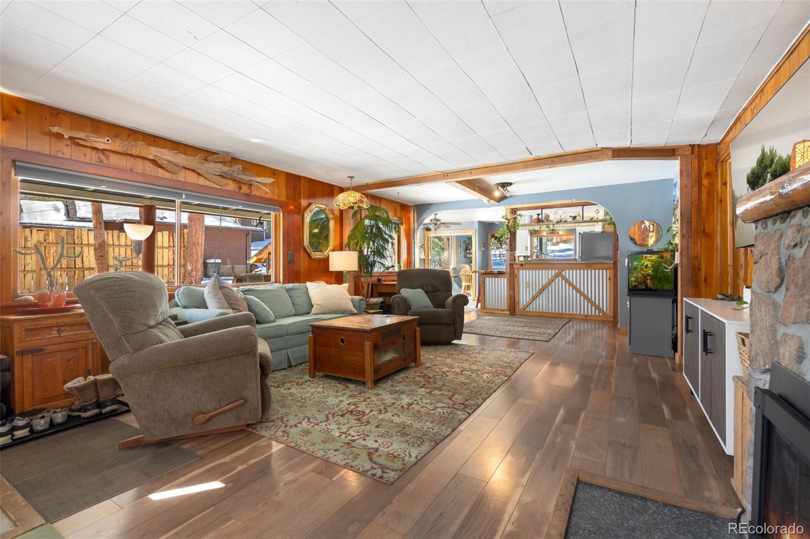 810 Larkspur Road Estes Park, CO 80517 - Photo 7 of 44 a living room with furniture a flat screen tv and a floor to ceiling window