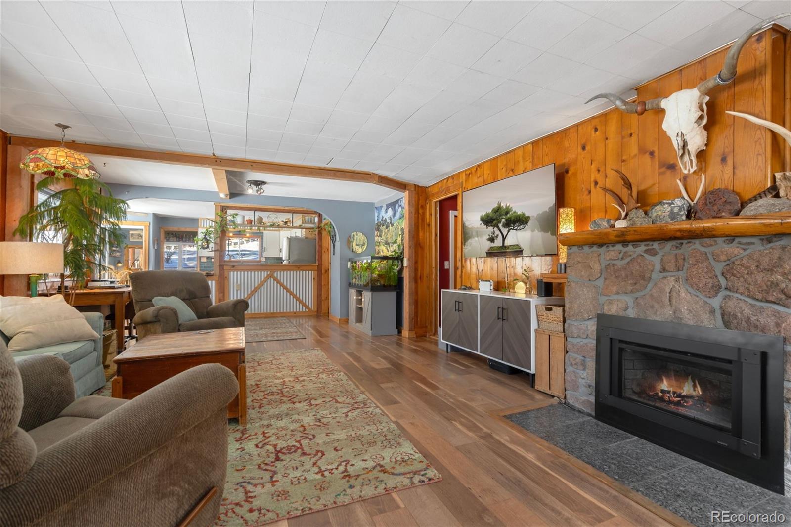 810 Larkspur Road Estes Park, CO 80517 - Photo 8 of 44 a living room with furniture a fireplace and a floor to ceiling window