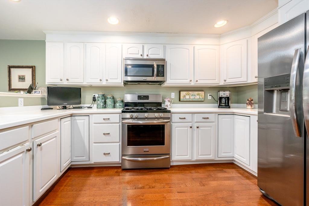 5 Classic Circle, Unit 484 Mashpee, MA 02649 - Photo 7 of 18 a kitchen with white cabinets and appliances