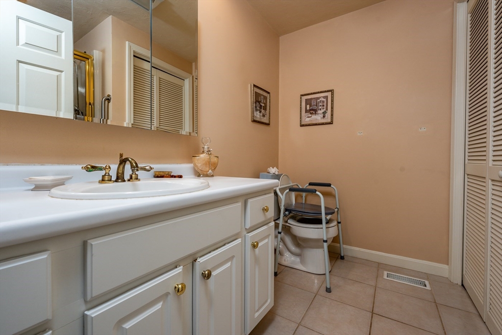 5 Classic Circle, Unit 484 Mashpee, MA 02649 - Photo 10 of 18 a bathroom with a sink a toilet and mirror