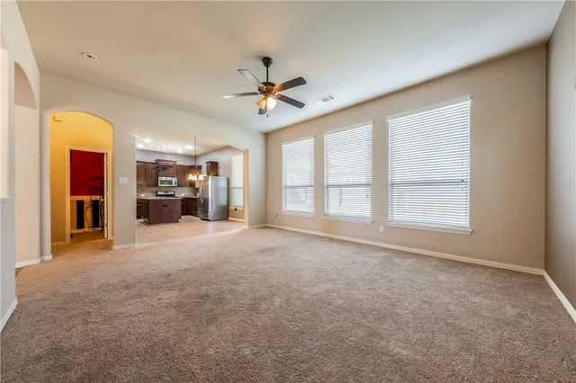 a view of an empty room with a fireplace and a window