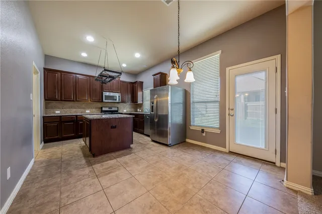a kitchen with stainless steel appliances granite countertop a refrigerator and a sink