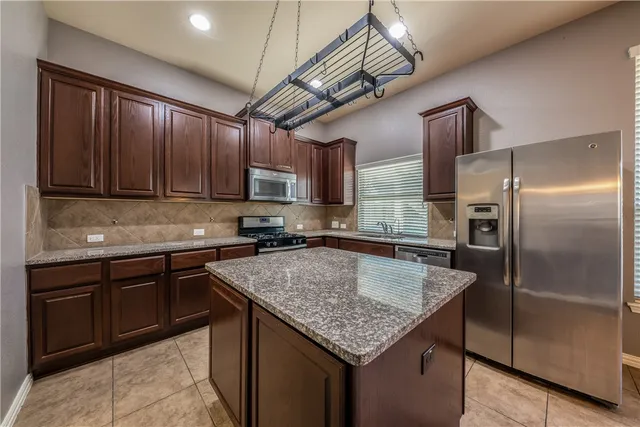 a kitchen with a center island and stainless steel appliances