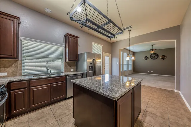 a kitchen with a sink a counter space and stainless steel appliances
