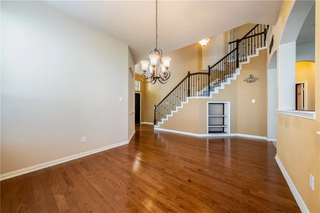 a view of a livingroom with wooden floor and staircase