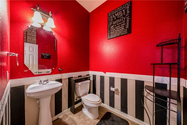 a bathroom with a toilet a sink and mirror