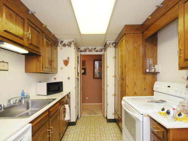 6301 North Sheridan Road, Unit 4O Chicago, IL 60660 - Photo 5 of 10 a kitchen with a sink a stove and cabinets