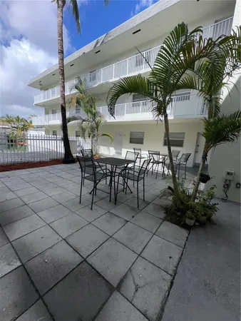 a view of a patio with table and chairs potted plants