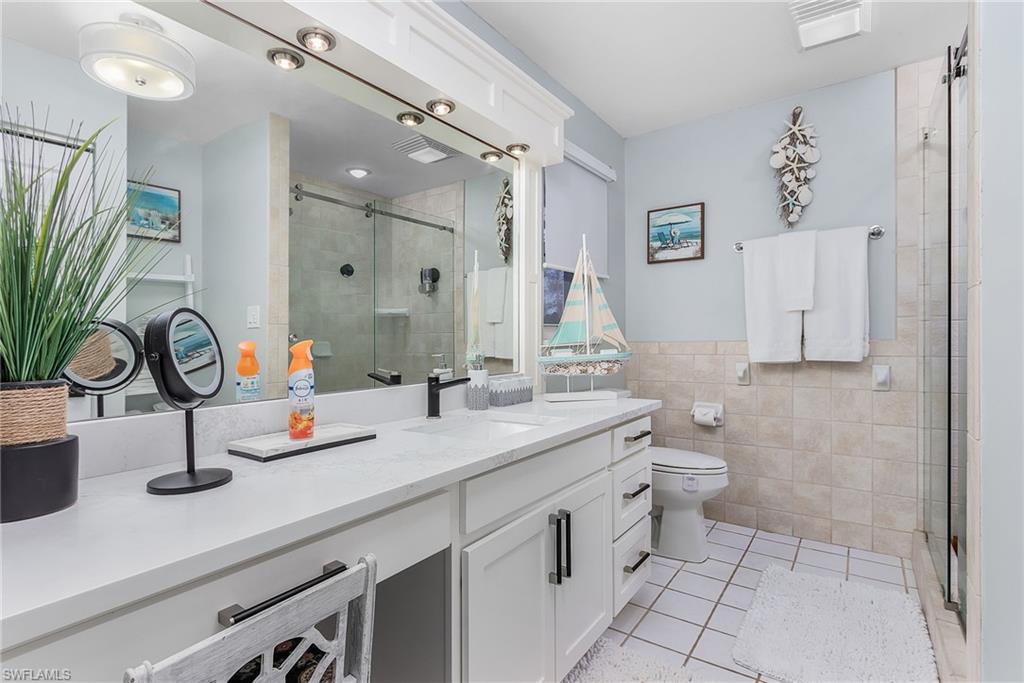 2950 Coach House Lane Naples, FL 34105 - Photo 17 of 50 a bathroom with a sink and a mirror