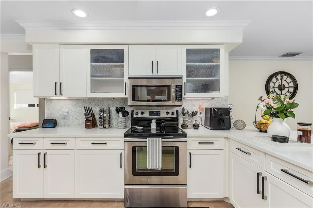 2950 Coach House Lane Naples, FL 34105 - Photo 20 of 50 a kitchen with white cabinets and white appliances
