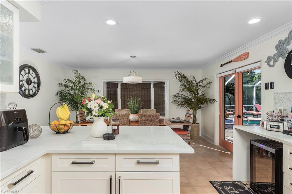 2950 Coach House Lane Naples, FL 34105 - Photo 22 of 50 an outdoor living room with fireplace furniture and a large window