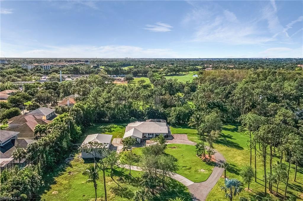 2950 Coach House Lane Naples, FL 34105 - Photo 35 of 50 an aerial view of a house with a yard and lake view